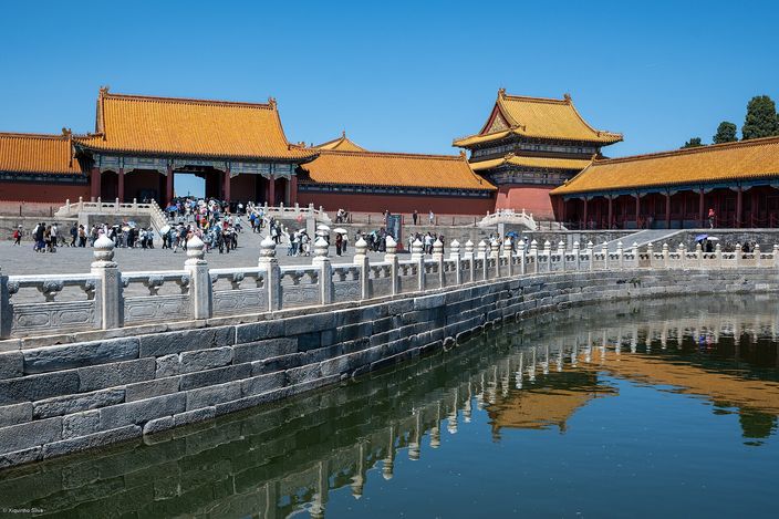 The Golden Water River inside the Forbidden City, its marble balustrade curving in front of the yellow-tiled halls, both reflected in the water