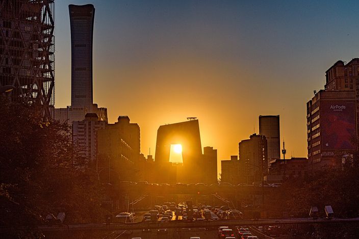 The towers of the eastern business district at sunset, the sun burning through the gap in the CCTV headquarters