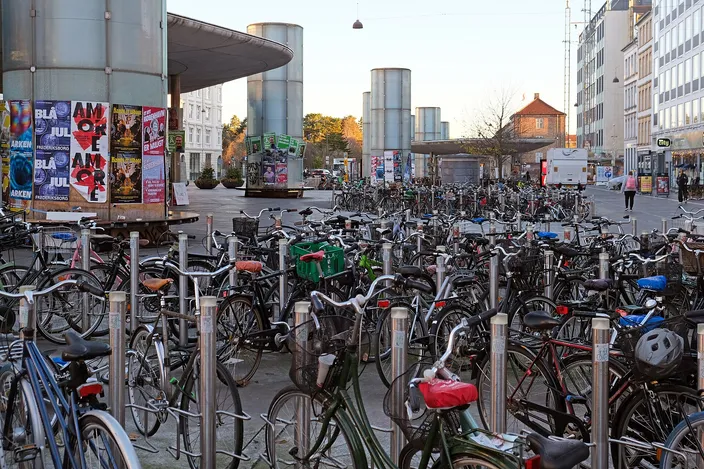 Rows of parked bicycles filling the square outside Nørreport station, with the station's tall cylindrical light towers behind