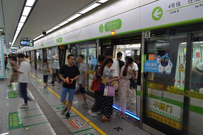 Commuters boarding a Hangzhou Metro Line 4 train at Citizen Center Station, with the platform screen doors open.