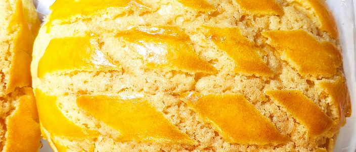 Close-up of freshly baked Hong Kong pineapple buns, their domed tops cracked into the golden sugar-crust pattern that gives the bun its name.