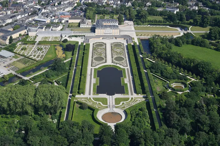 Aerial view of Augustusburg Palace at Brühl and its formal baroque garden, with parterres and a long pool stretching away from the palace between lines of trees