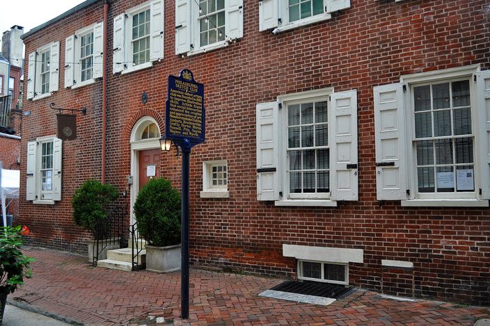 A three-storey redbrick Philadelphia townhouse on cobbled Camac Street, with white-shuttered windows, an arched doorway and a blue-and-gold state historical marker for the Philadelphia Sketch Club on the brick sidewalk