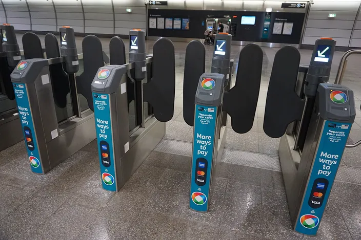 Opal card fare gates at a Sydney Metro station, each with 'More ways to pay' signage showing contactless and Opal tap readers, an empty concourse behind